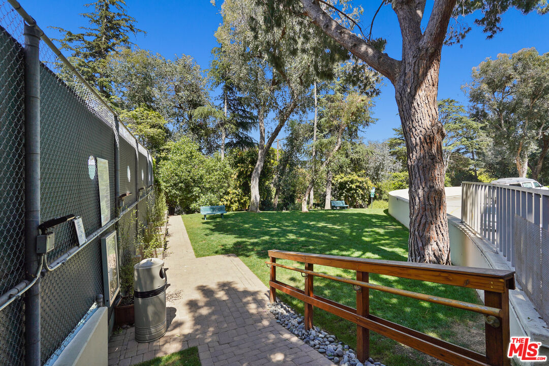 2170 Century Park East, Unit 104 Los Angeles, CA 90067 - Photo 30 of 42 a view of backyard with wooden fence and large trees