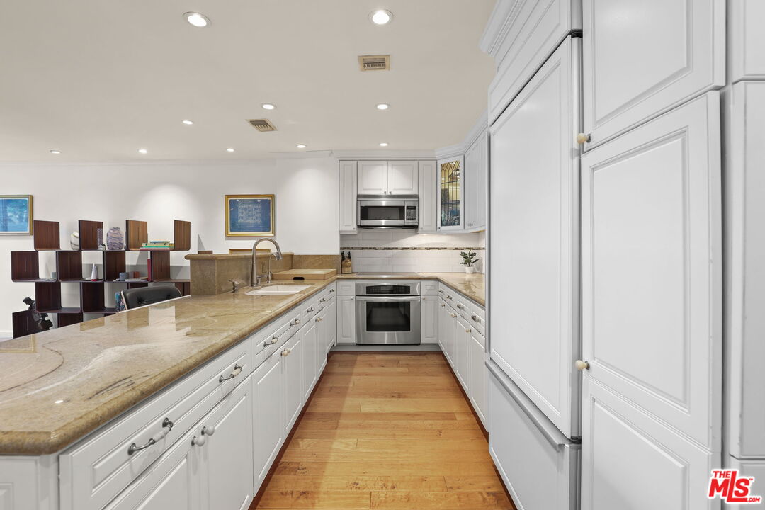 2170 Century Park East, Unit 104 Los Angeles, CA 90067 - Photo 10 of 42 a large kitchen with stainless steel appliances kitchen island granite countertop a large counter top a stove and a sink