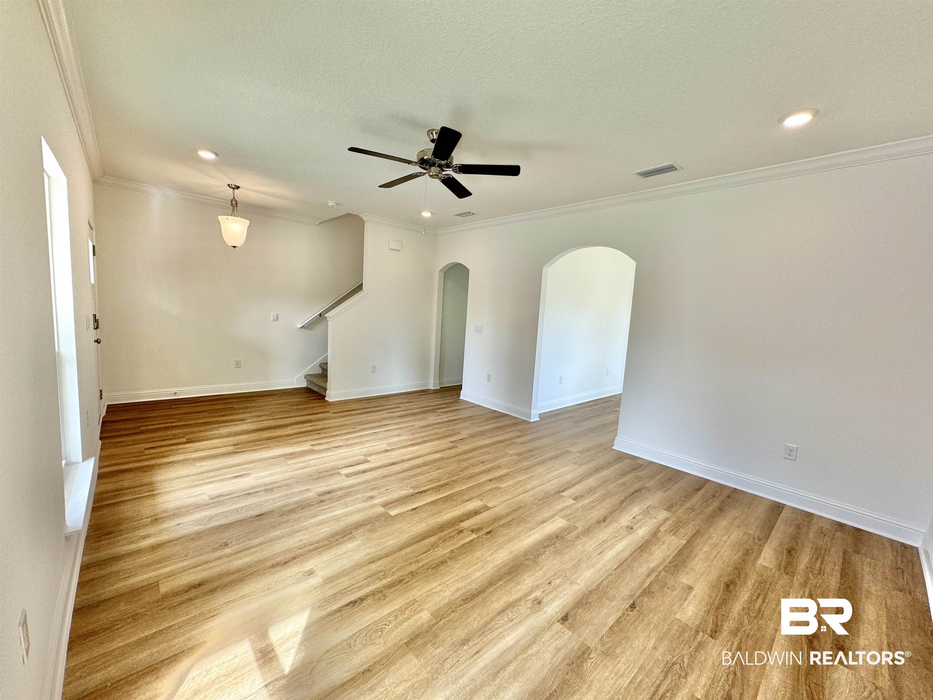 27491 Canal Road Orange Beach, AL 36561 - Photo 9 of 20 Unfurnished room featuring light wood-type flooring, ornamental molding, and ceiling fan