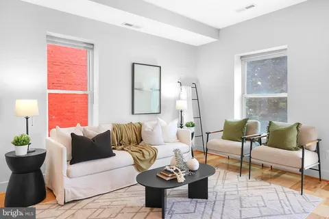 a living room with furniture kitchen view and a table