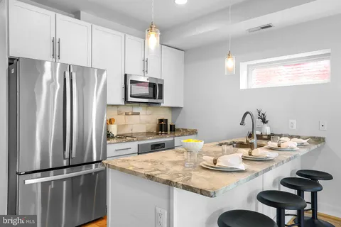 a kitchen with a sink dining table and chairs