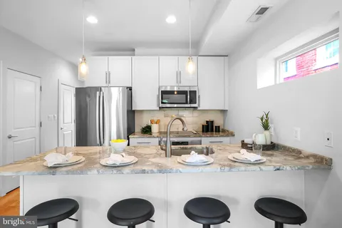 a kitchen with refrigerator a microwave a sink and cabinets