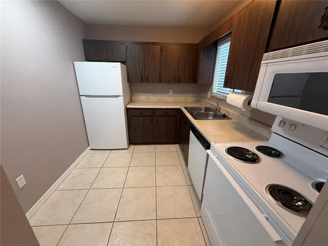 a kitchen with a refrigerator sink stove and cabinets