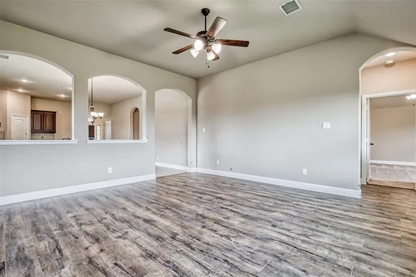 a view of a livingroom with a fireplace a chandelier and wooden floor