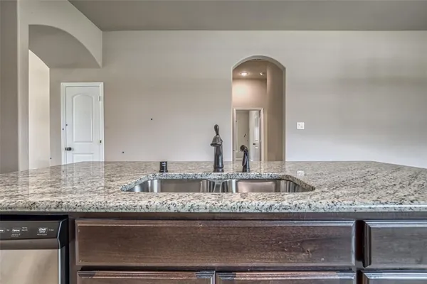 a kitchen with stainless steel appliances granite countertop a kitchen island a stove a sink and a refrigerator