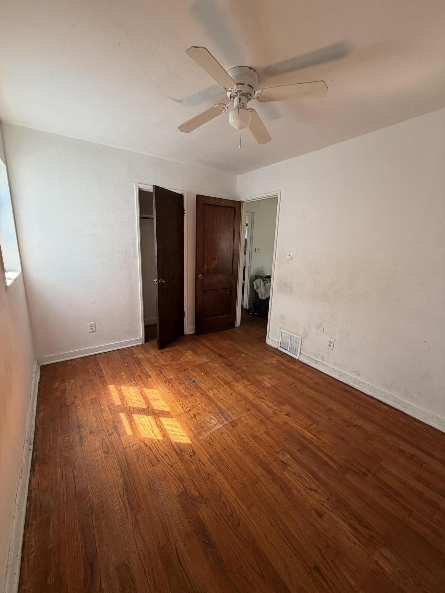1724 Fillmore Street Gary, IN 46407 - Photo 3 of 8 an empty room with wooden floor and windows