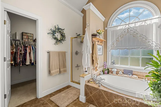 a bathroom with a tub a mirror and a shower