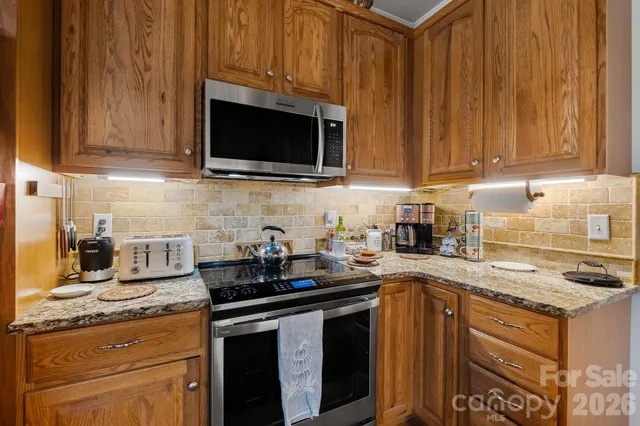 a kitchen with stainless steel appliances granite countertop a sink stove and microwave
