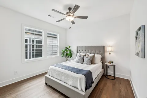 a bedroom with a large bed chandelier and a window