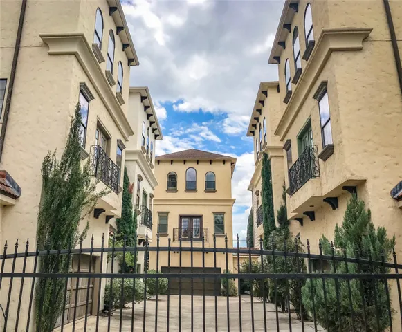 a view of a brick house with large windows and a flower plants
