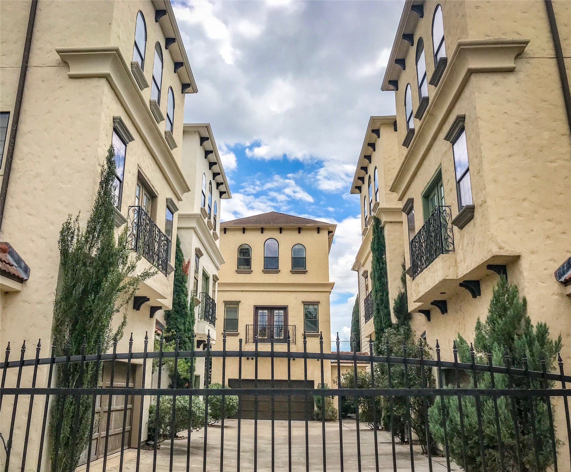 a view of a brick house with large windows and a flower plants