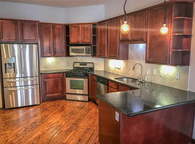 a kitchen with stainless steel appliances granite countertop a sink stove and refrigerator