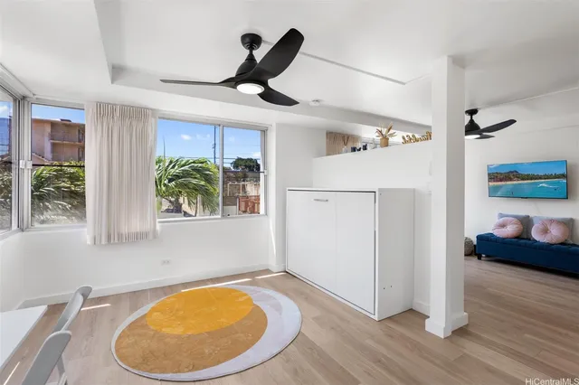 a view of a livingroom with wooden floor and a ceiling fan