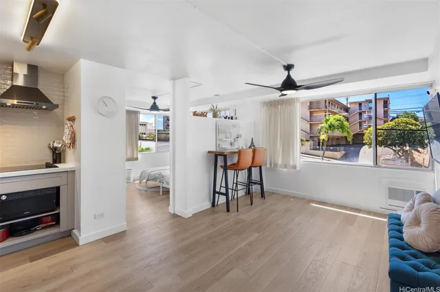 a living room with stainless steel appliances kitchen island furniture and a fireplace