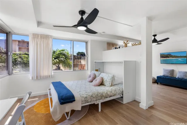 a bedroom with furniture and a large window