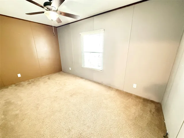 an empty room with a window and a fan