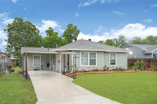 a front view of a house with a garden and yard
