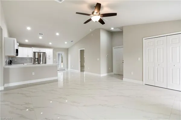 a view of kitchen with stainless steel appliances granite countertop refrigerator stove top oven and cabinets