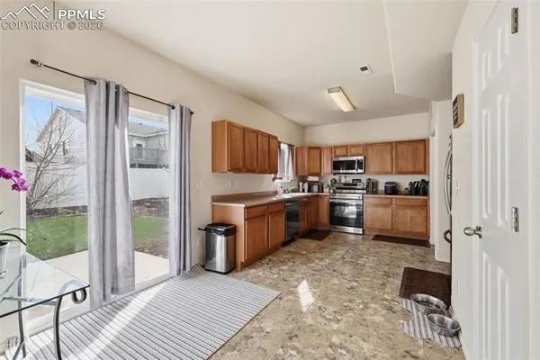 a kitchen with a cabinets a sink a window and stainless steel appliances
