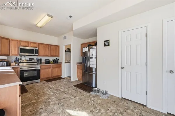 a kitchen with stainless steel appliances granite countertop a refrigerator oven a sink dishwasher and white cabinets with wooden floor