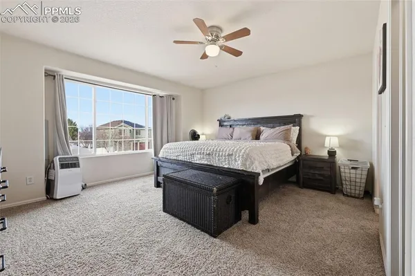 a living room with furniture a bed and a large window with wooden floor