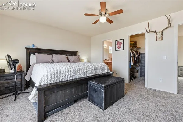 a spacious bedroom with a bed and a chandelier