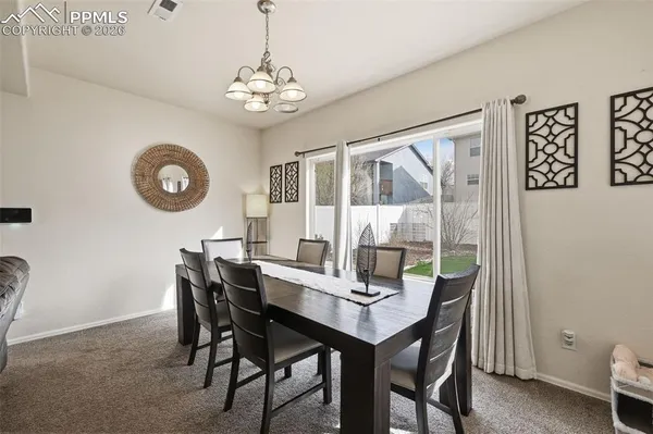 a view of a dining room with furniture and chandelier