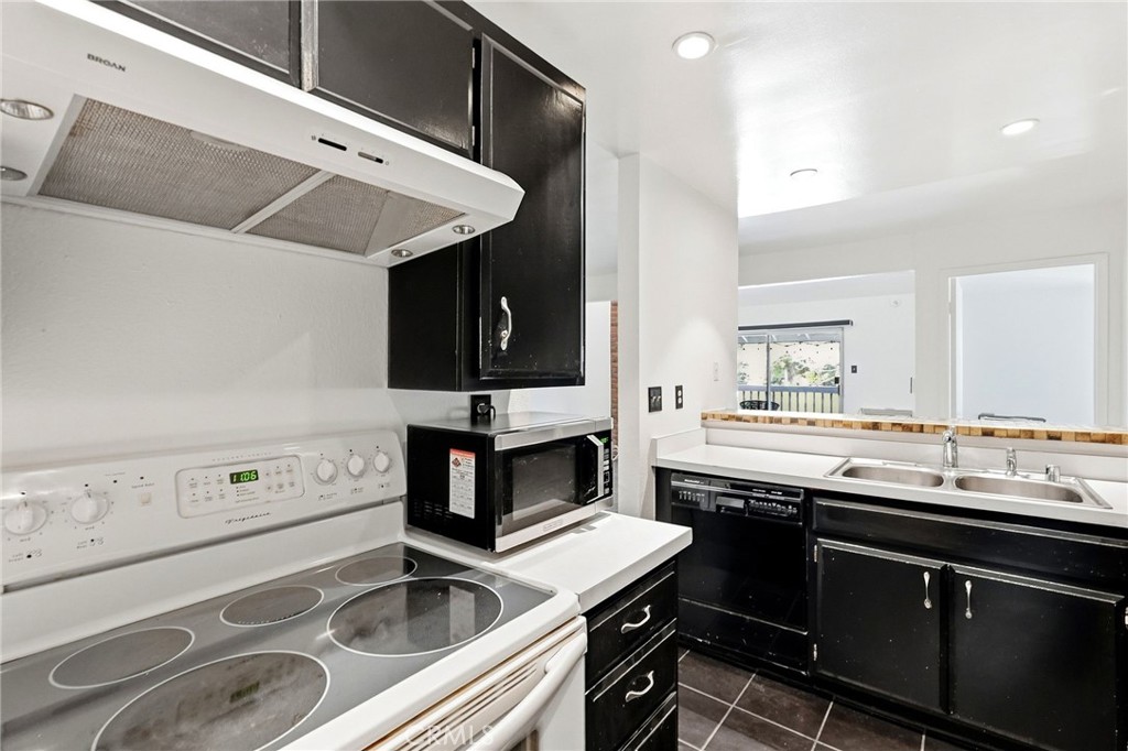 7890 East Spring Street, Unit 11E Long Beach, CA 90815 - Photo 22 of 40 a kitchen with a sink stove and cabinets