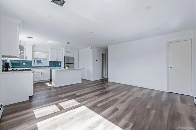 a view of a kitchen with wooden floor and a sink