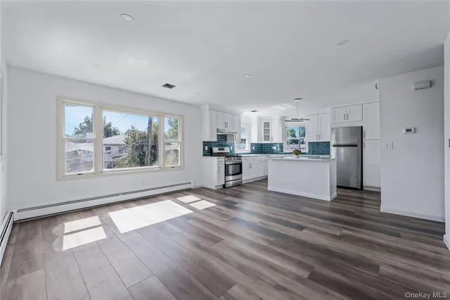 a view of kitchen with wooden floor and electronic appliances