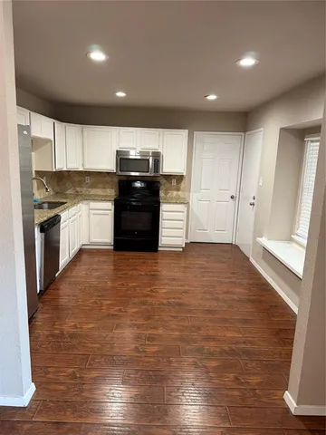 a large kitchen with a stove and a refrigerator