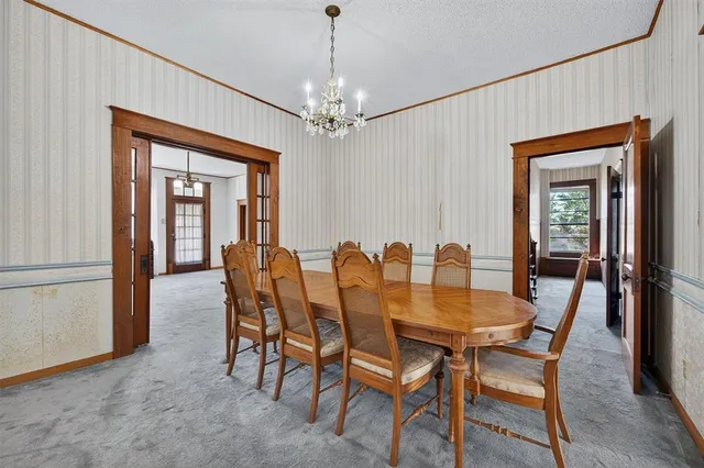 a dining room with furniture a chandelier and wooden floor