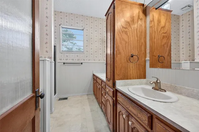 a bathroom with a granite countertop sink a mirror a vanity and shower