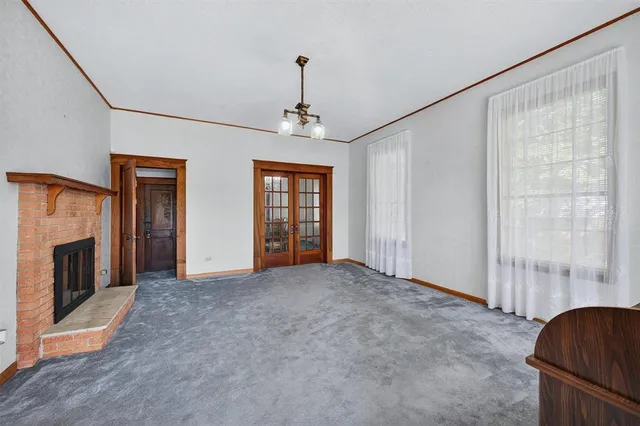 a view of empty room with fireplace and windows