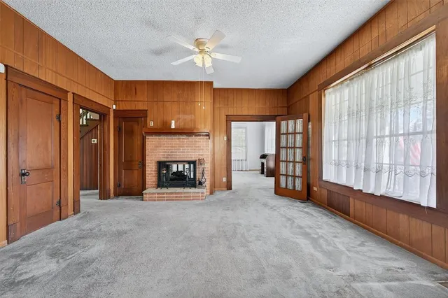 a view of an empty room with a fireplace and a window