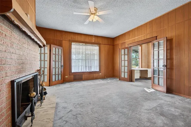 an empty room with windows and fireplace