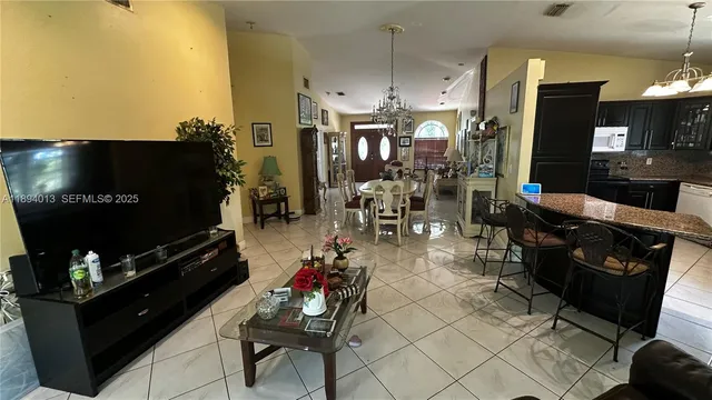 a living room with furniture a flat screen tv and kitchen view