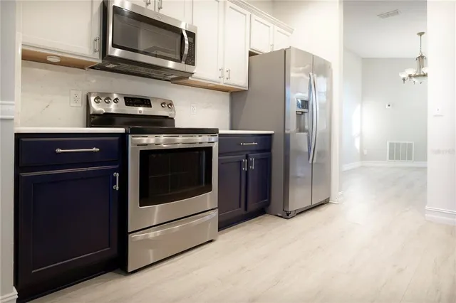 a kitchen with stainless steel appliances granite countertop a stove a sink and a refrigerator