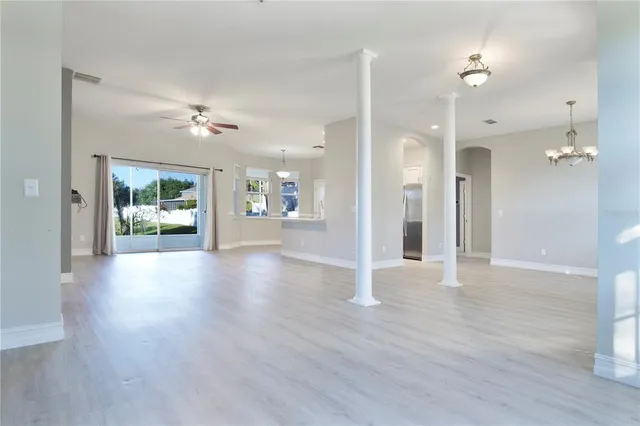 a view of a hallway with wooden floor and a chandelier