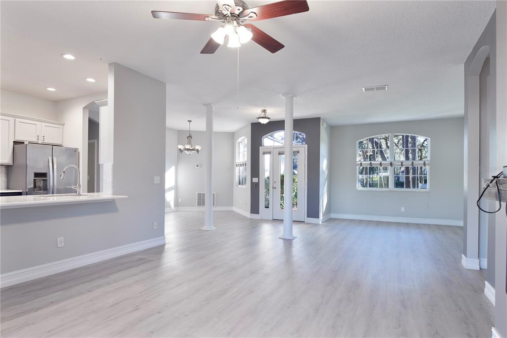 2560 Tall Maple Loop Ocoee, FL 34761 - Photo 10 of 32 a view of a hallway with wooden floor and a chandelier
