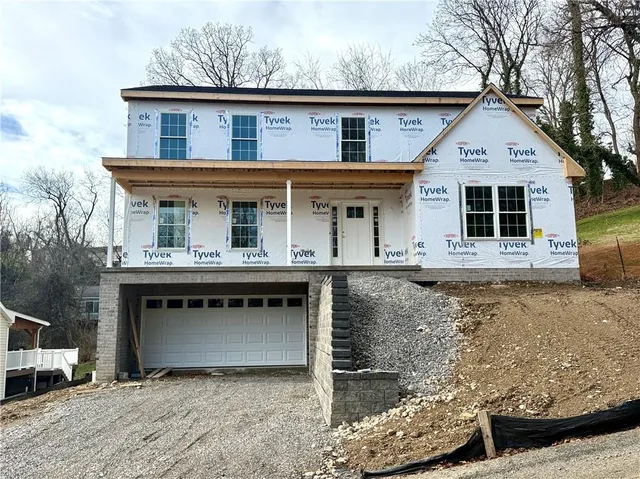 a front view of a house with a garden and yard