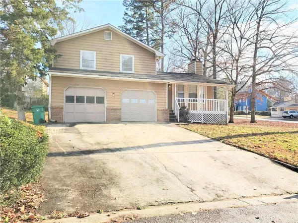 a front view of a house with a yard and trees