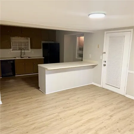 a view of kitchen with stainless steel appliances cabinets and wooden floor