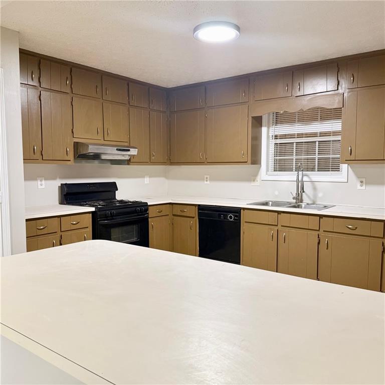 524 Julius Drive Stone Mountain, GA 30087 - Photo 5 of 17 a kitchen with stainless steel appliances granite countertop a sink and cabinets