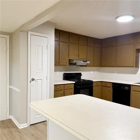 a kitchen with a refrigerator sink and cabinets