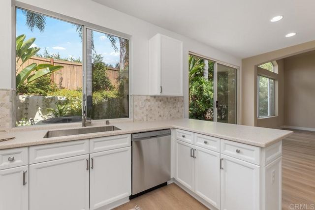 a white kitchen with a large window