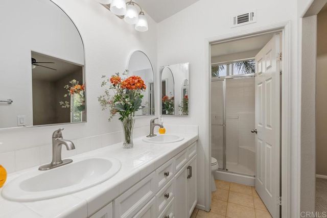 a bathroom with double vanity sink a vanity and a mirror