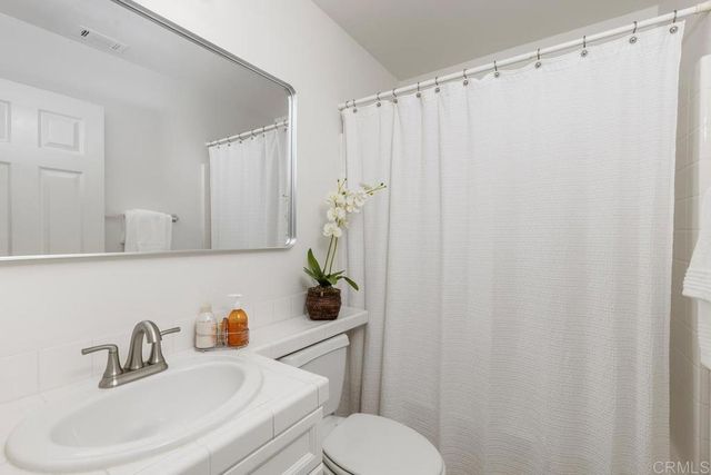 a bathroom with a sink a toilet and shower curtain