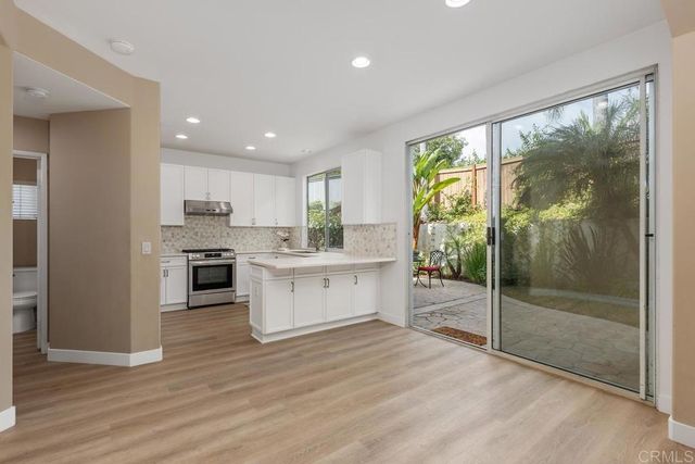 a kitchen with a refrigerator and white cabinets