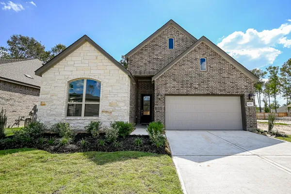 a front view of a house with a yard and garage